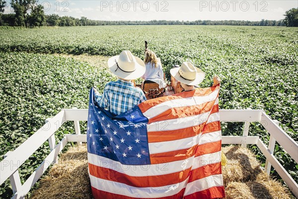 Caucasian children holding American flag on hay ride