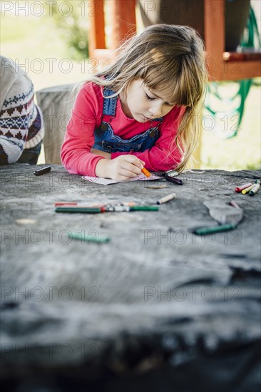 Caucasian girl coloring outdoors