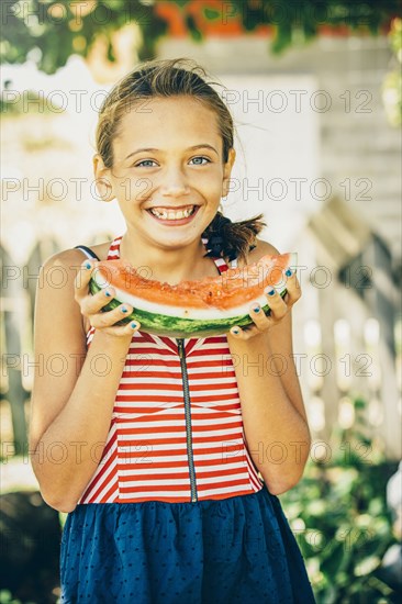 Caucasian girl eating watermelon outdoors