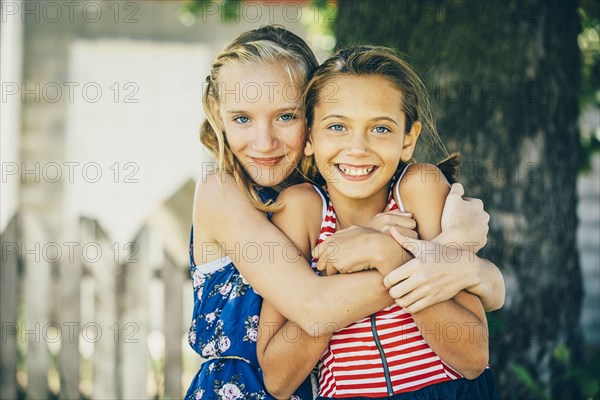 Caucasian girls hugging outdoors