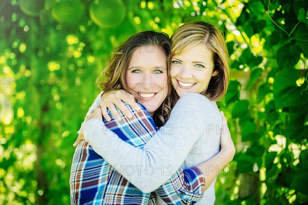 Caucasian women hugging under tree