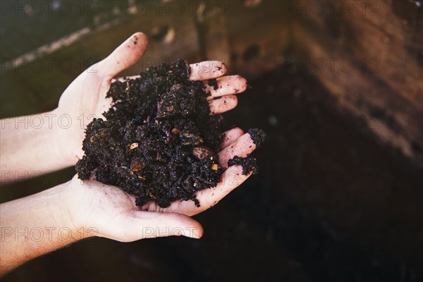 Close up of hands holding wet dirt