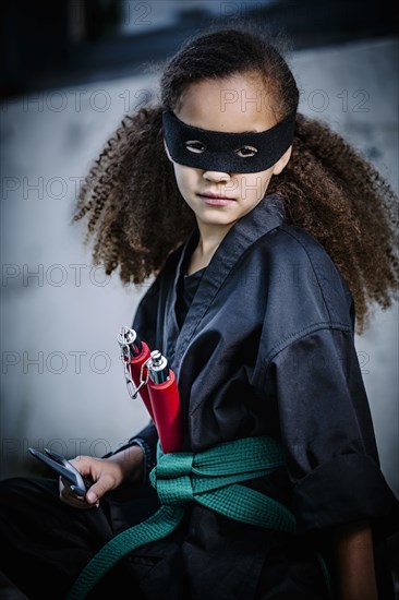 Mixed race girl in martial arts uniform and mask