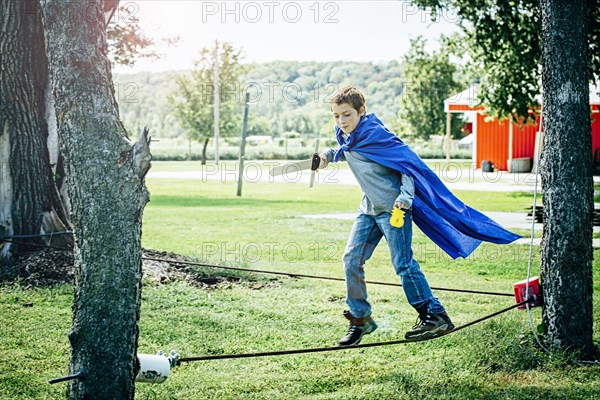 Caucasian boy in costume balancing on tightrope