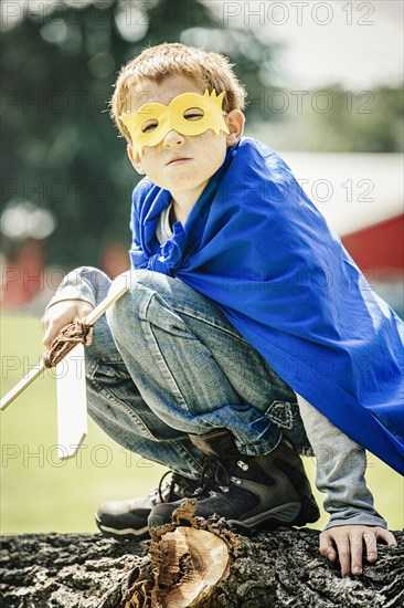 Caucasian boy wearing costume and playing with sword