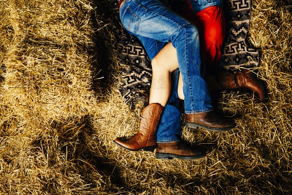 Caucasian couple laying on haystacks