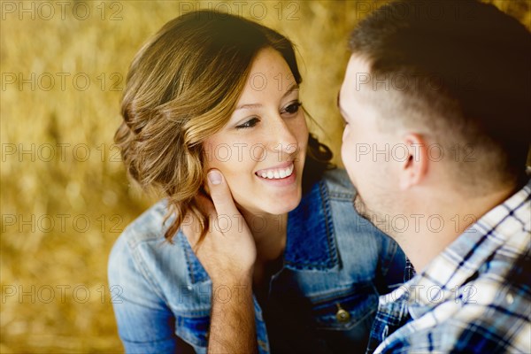 Caucasian man holding face of girlfriend