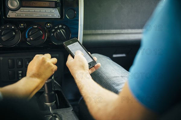 Caucasian man using cell phone in car