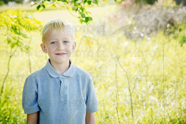 Caucasian boy smiling in tall grass