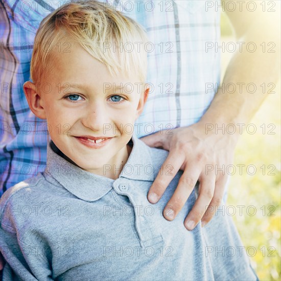Caucasian boy smiling with father outdoors