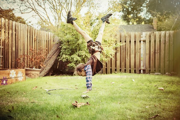 Mixed race girl wearing cowboy costume in backyard