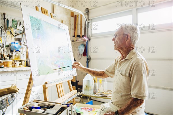 Caucasian artist painting in garage