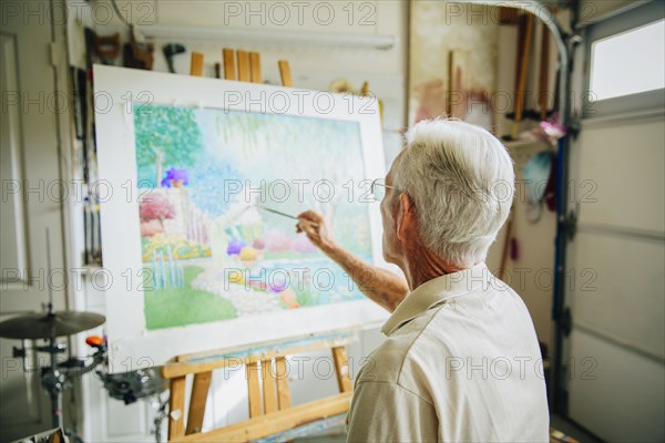 Caucasian artist painting in garage