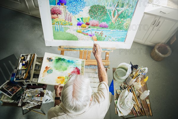 Caucasian artist painting in studio