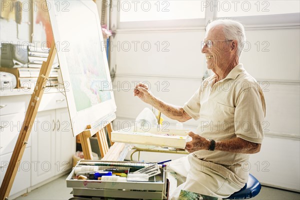 Caucasian artist painting in garage