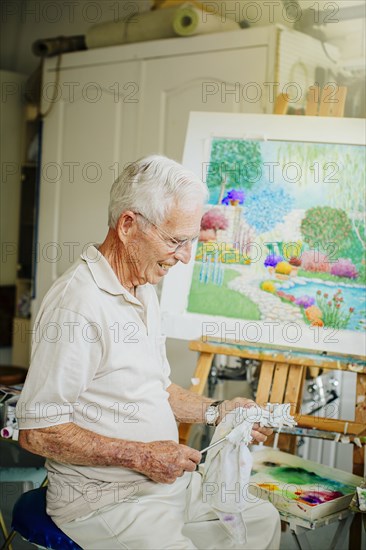 Caucasian artist cleaning brushes in studio