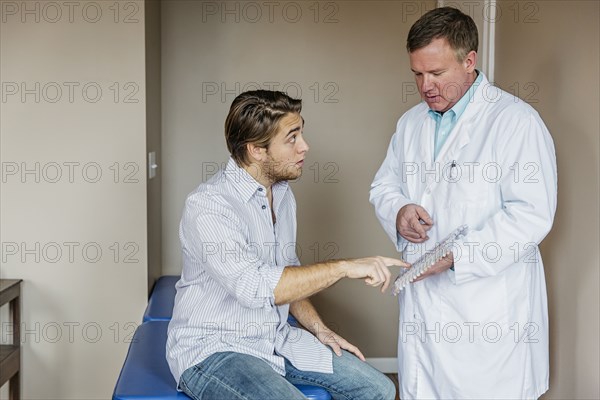 Caucasian doctor and patient viewing model of spine