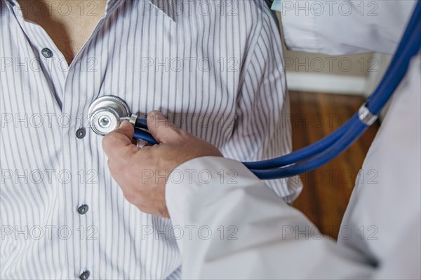 Caucasian doctor listening to heartbeat of patient