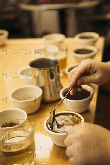 Caucasian barista tasting coffee in coffee shop