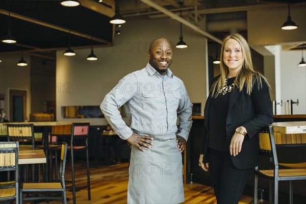 Waiter and businesswoman smiling in cafe