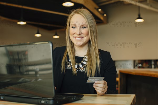 Caucasian businesswoman shopping online in cafe