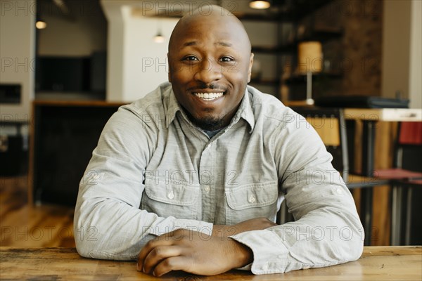 Black man smiling at counter in cafe