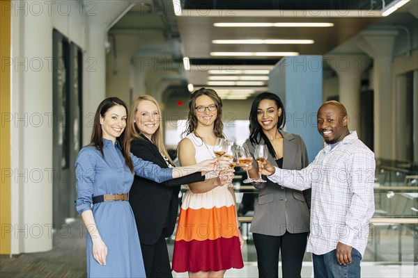 Business people toasting with wine in office