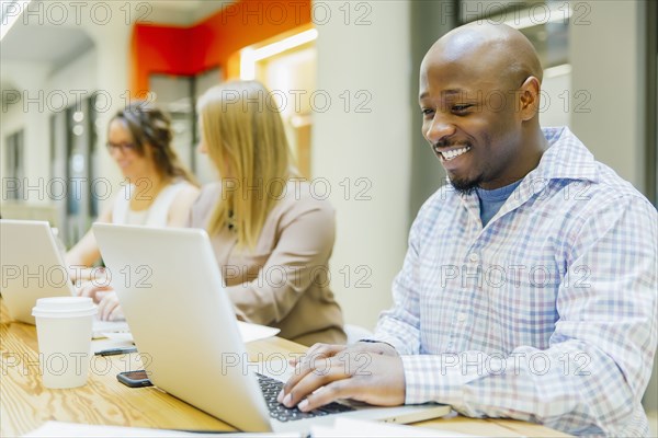 Business people working on laptops in office meeting