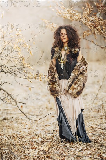 Mixed race woman wearing stylish clothes in field