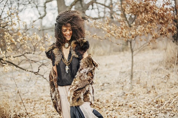 Mixed race woman wearing stylish clothes in field