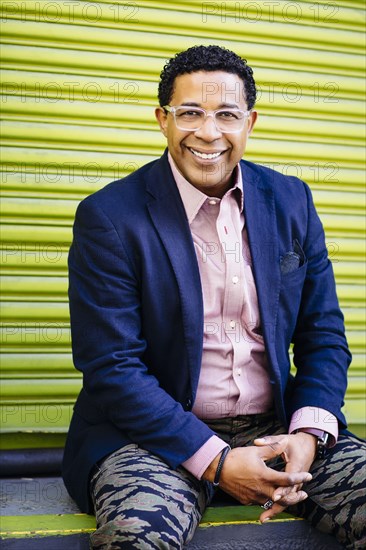 Mixed race businessman sitting at loading dock door