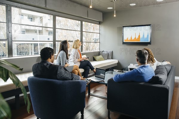 Business people watching presentation in office lounge