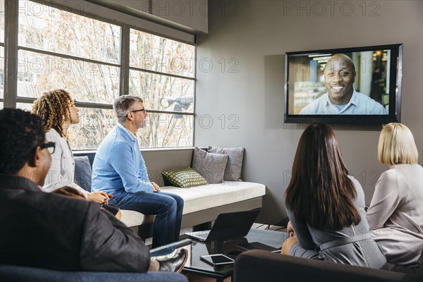 Business people watching teleconference in office meeting