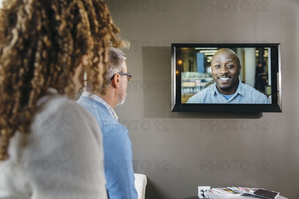 Business people watching teleconference in office meeting