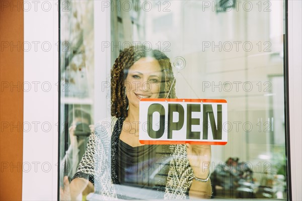 Mixed race store owner opening door