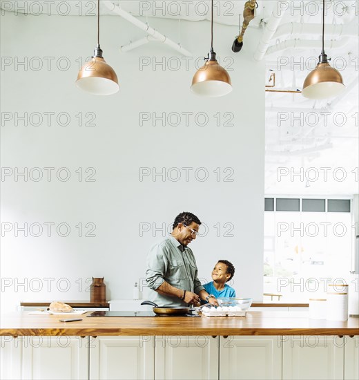 Father and son cooking in kitchen