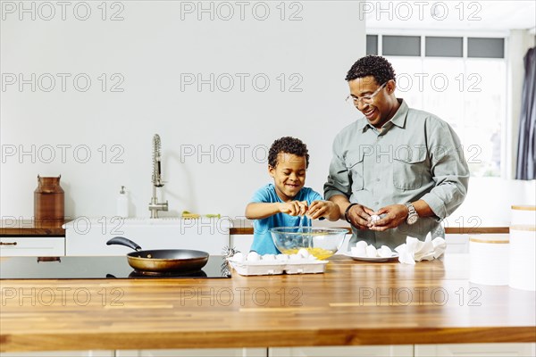 Father and son cooking in kitchen