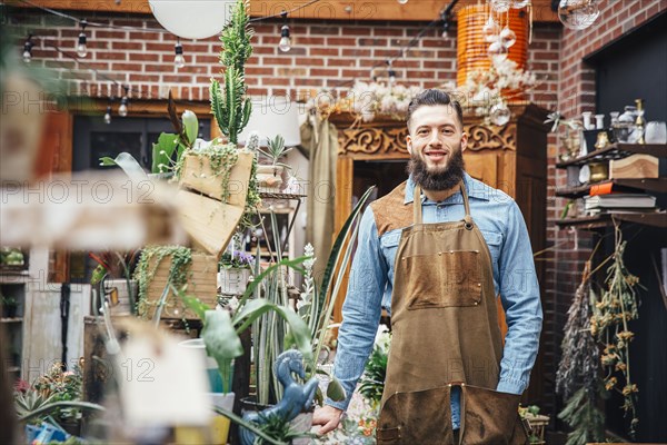 Caucasian employee smiling in plant nursery