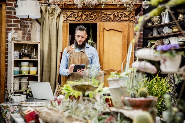 Caucasian employee using digital tablet in plant nursery