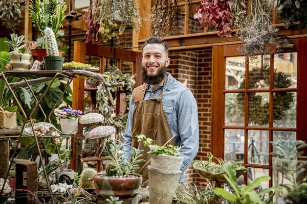 Caucasian employee smiling in plant nursery