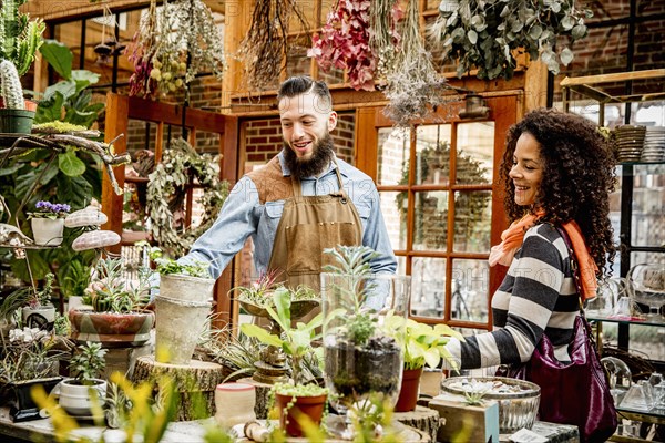 Employees examining plants in nursery