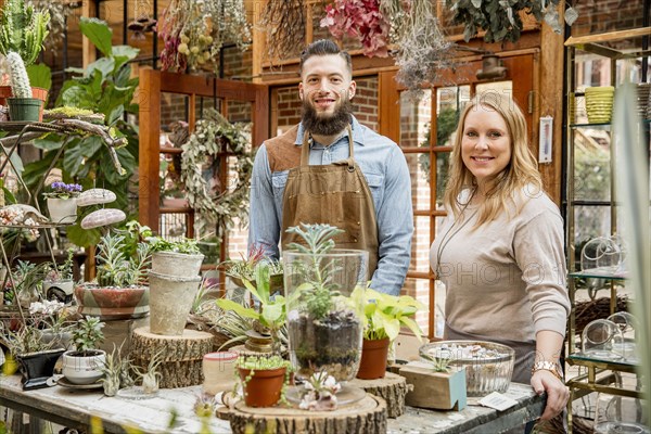 Caucasian employees smiling in plant nursery