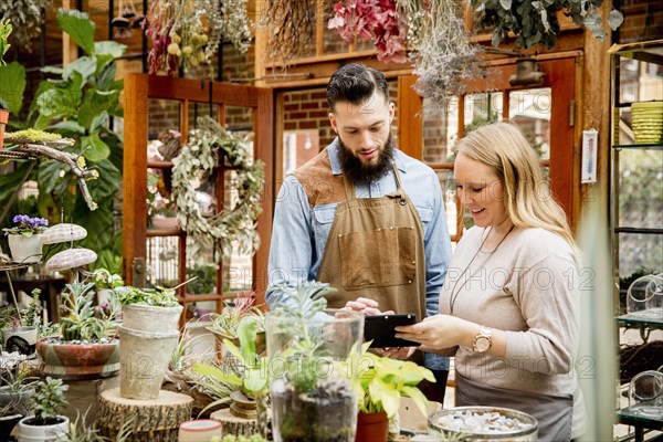 Caucasian employees using digital tablet in plant nursery