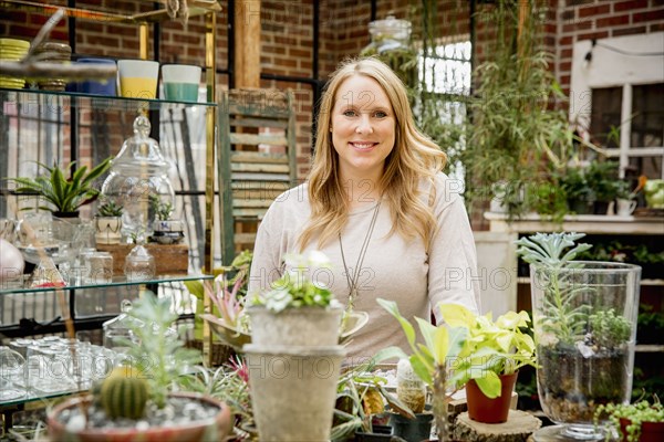 Caucasian employee smiling in plant nursery