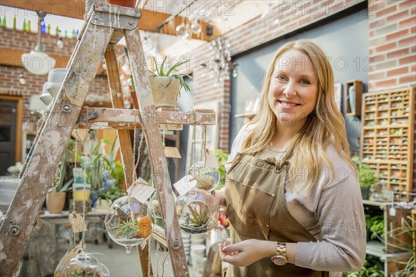 Caucasian employee with plants in nursery