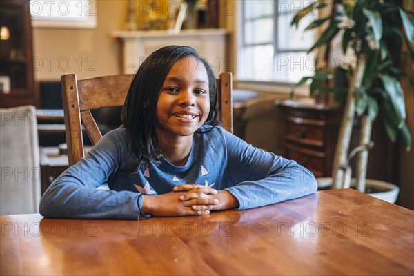 Black girl smiling at table