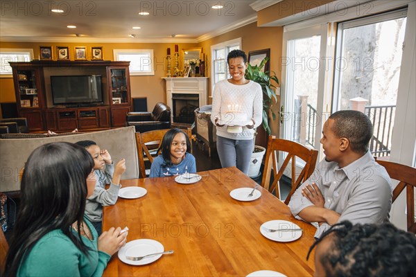 Black family celebrating birthday at table