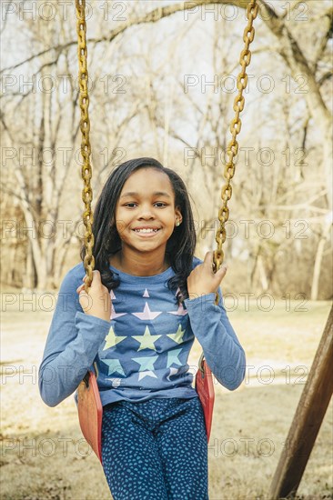 Black girl sitting on swing