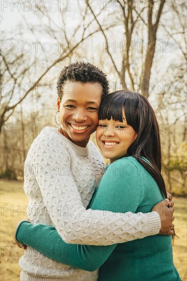 Black mother and daughter hugging outdoors
