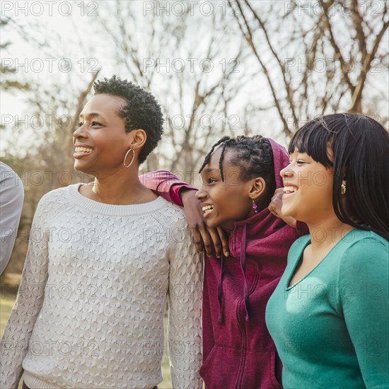 Black mother and daughters smiling outdoors